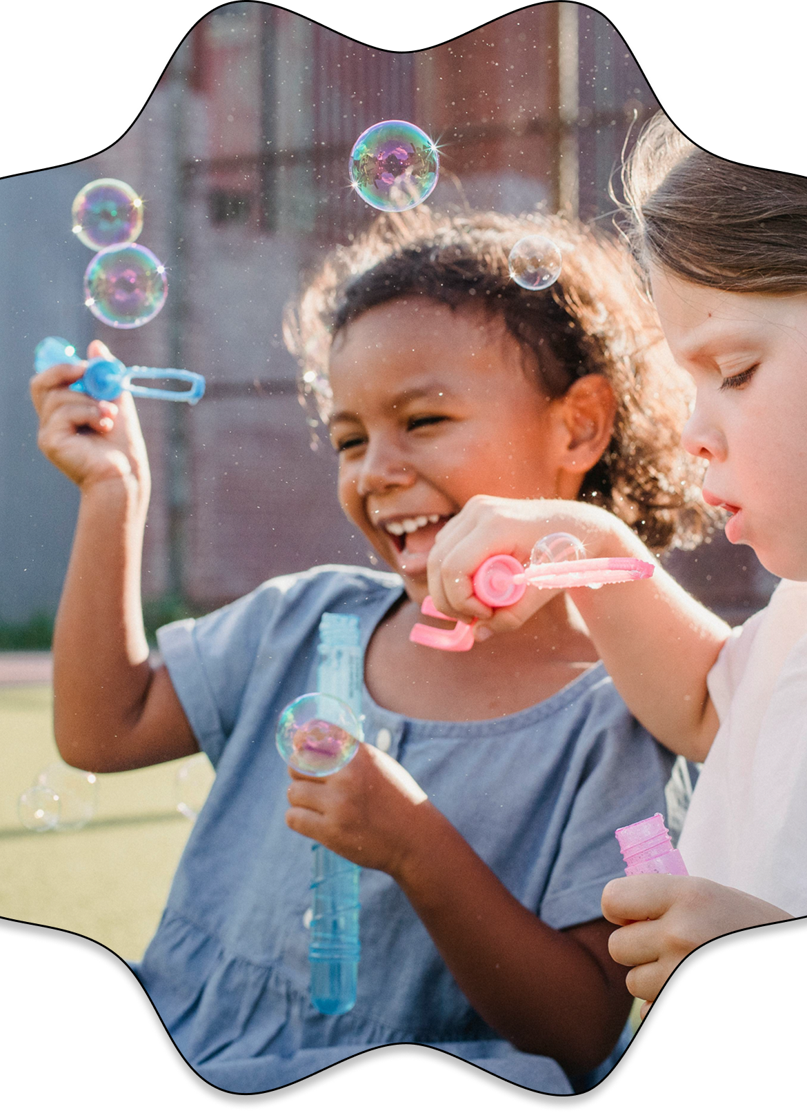 Two children blowing bubbles together outdoors