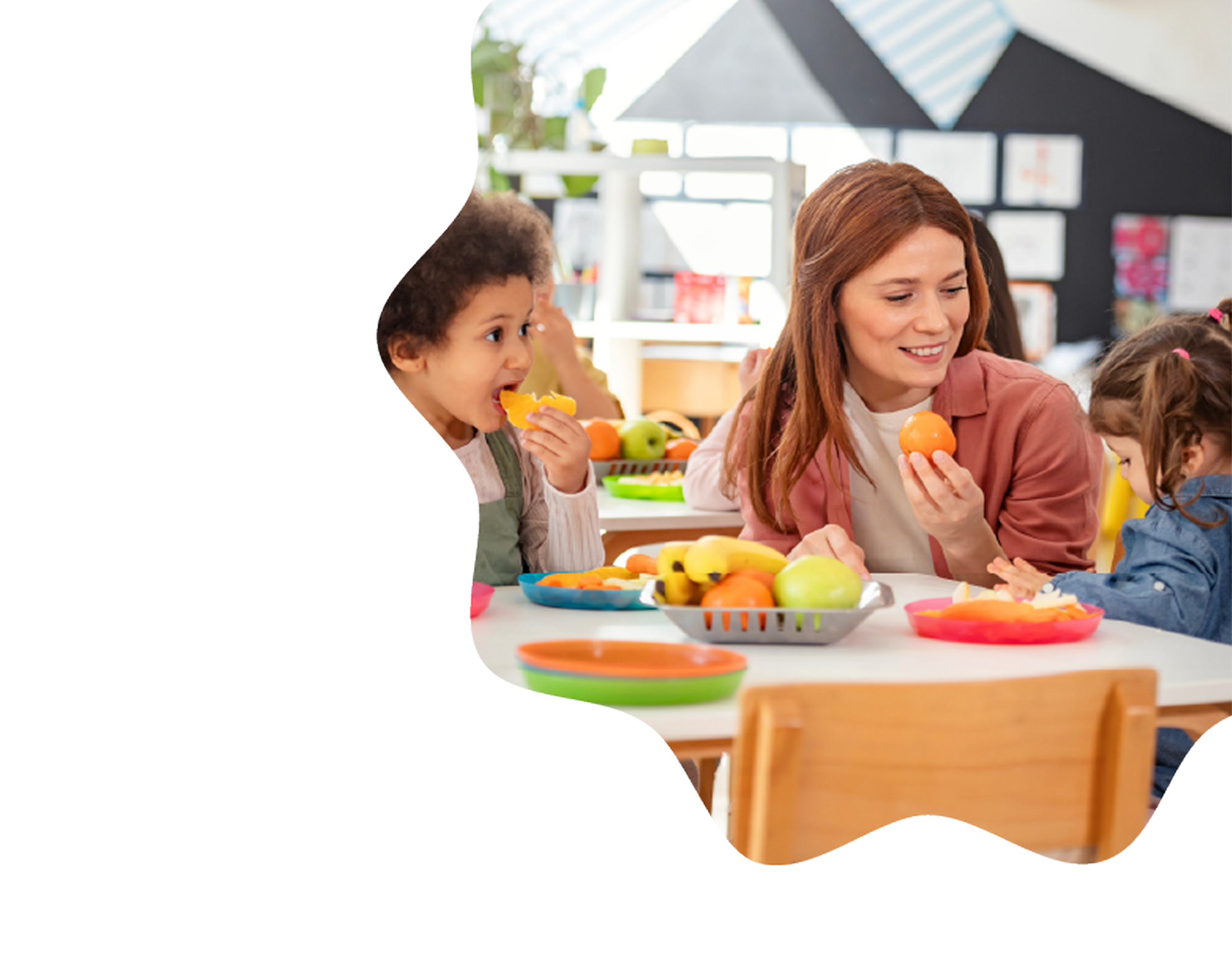 A caregiver and children eating fresh fruit together at a table